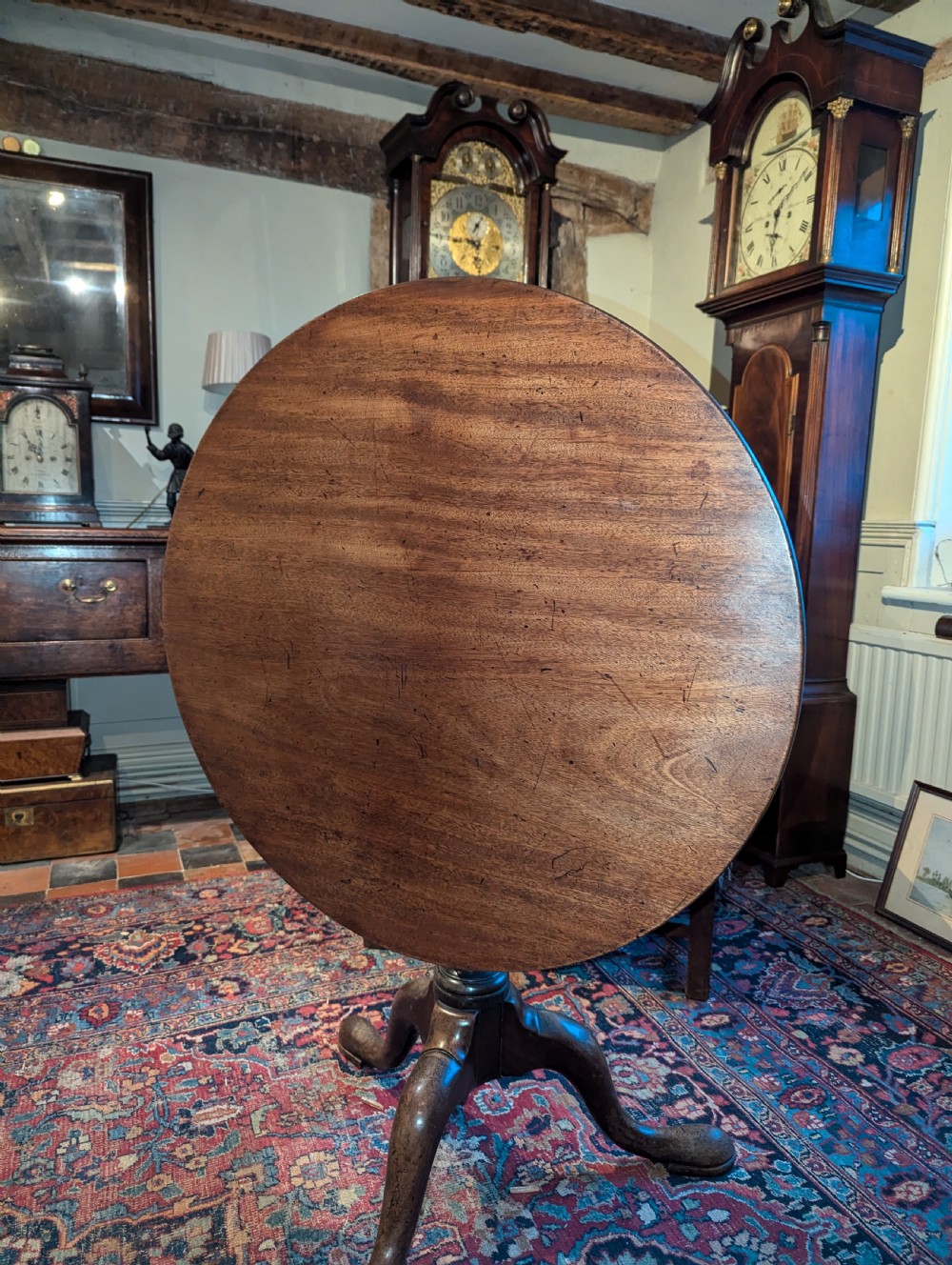 A George III mahogany tripod table featuring a circular top over a turned stem with a spiral collar and three cabriole legs. View VI