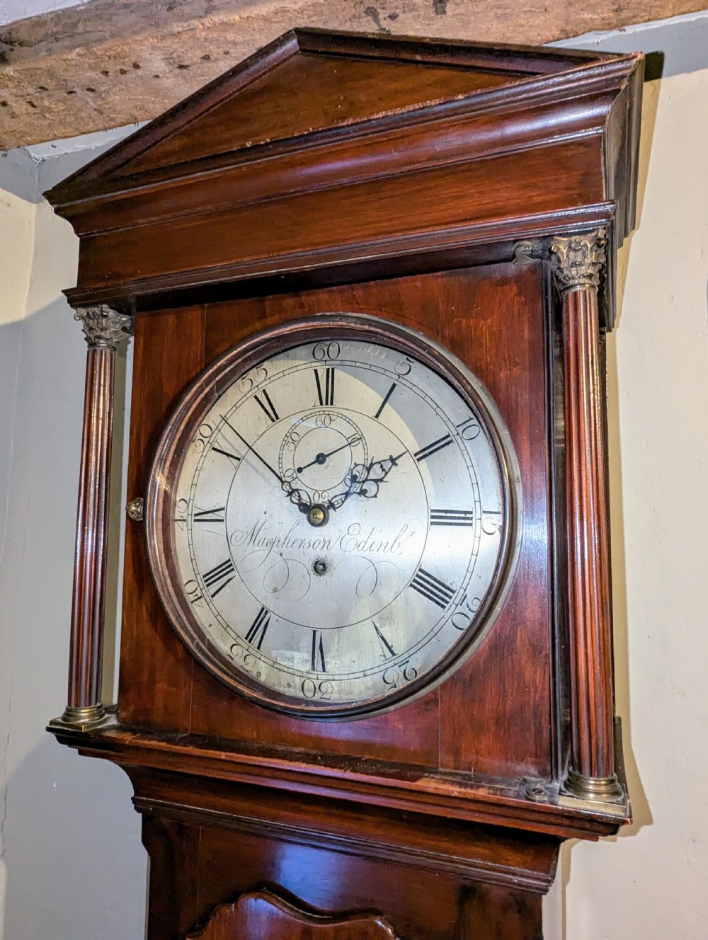An 18th-century mahogany regulator longcase clock featuring an architectural pediment hood, circular brass dial signed Macpherson Edinb, and fluted columns. View V