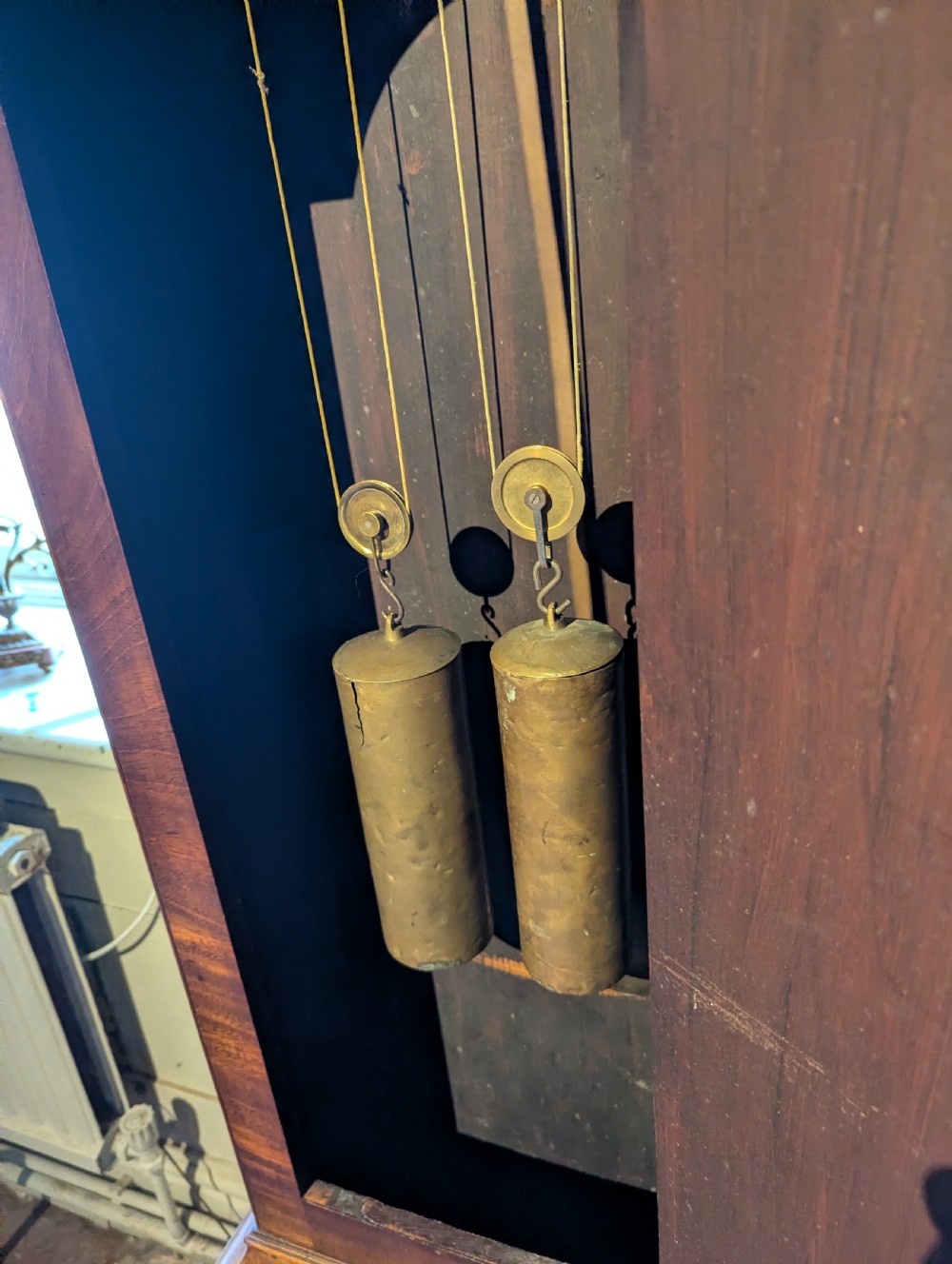 An 18th-century mahogany longcase clock featuring brass eagle finials, an arched dial hood, and a flame mahogany trunk door. View VIII