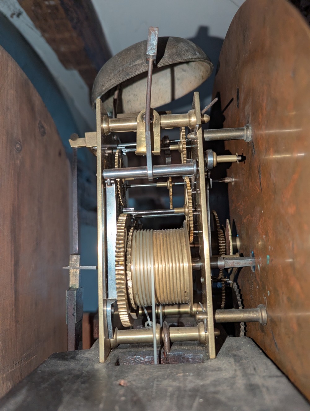 An early nineteenth-century flame mahogany domestic regulator longcase clock featuring an arched hood, circular dial with subsidiary dials, turned side columns, and an enclosed wooden base. View X