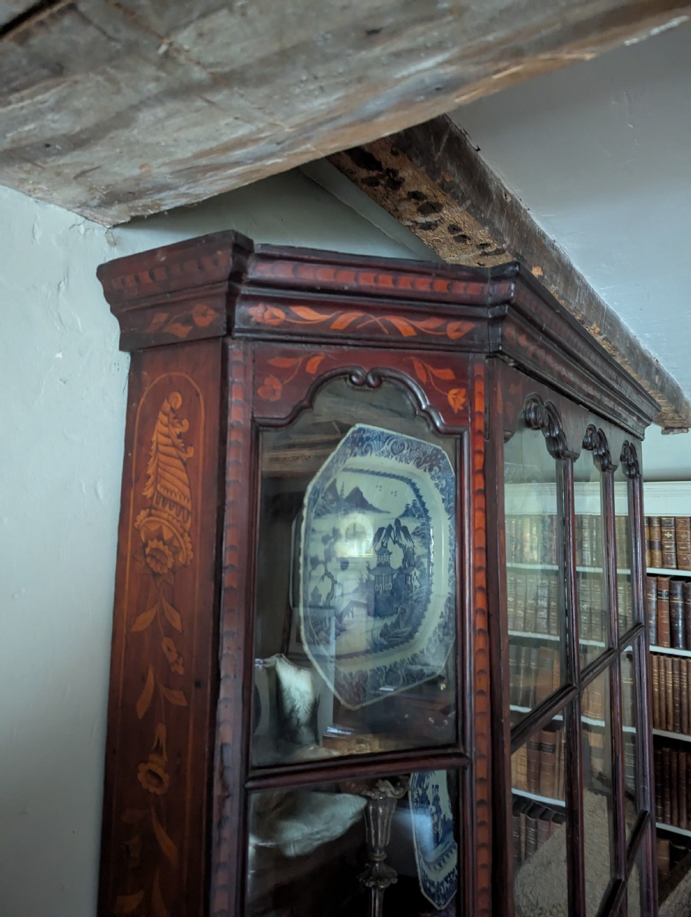 A 19th-century Dutch wall-mounted display cabinet crafted from dark wood with detailed floral marquetry inlay and multi-pane glazed doors. View V