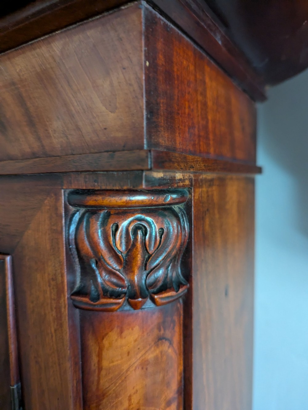 A 19th-century flame mahogany longcase regulator clock with an arched pediment, round silvered dial, and panelled wooden trunk. View VII