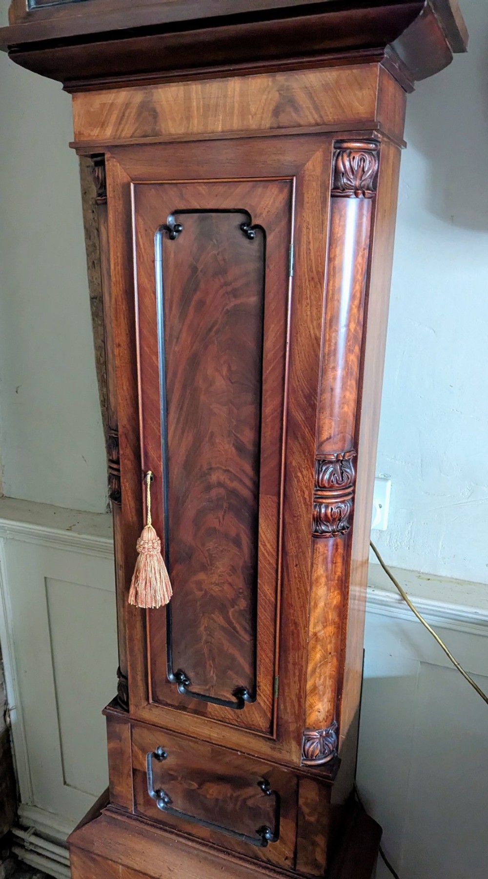 A 19th-century flame mahogany longcase regulator clock with an arched pediment, round silvered dial, and panelled wooden trunk. View XI