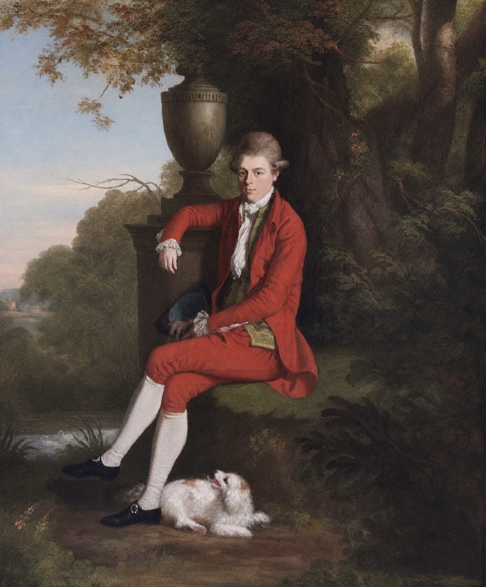 An eighteenth-century oil portrait of a gentleman in a red coat seated in a landscape next to a dog, presented in a carved giltwood frame. View II