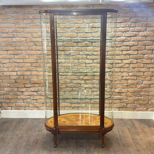 fig 1. An Edwardian mahogany and curved glass shop display cabinet featuring tiered glass shelves and a parquet inlaid timber base.
