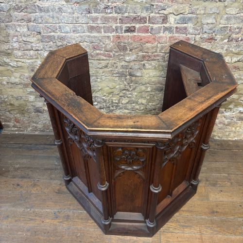 fig 1. A late nineteenth-century carved oak church pulpit featuring Gothic tracery, floral medallions, and integrated corner columns.