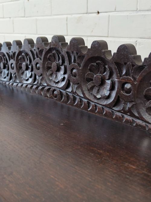fig 6. Dark carved oak hall table featuring a carved floral gallery, relief apron, bobbin-turned front legs, and lower stretcher.