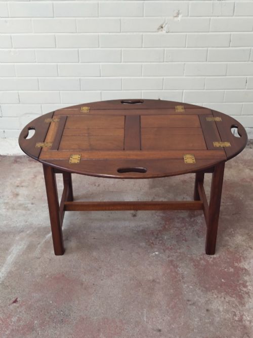 fig 2. An antique mahogany butlers tray with hinged folding sides and brass fittings resting on a rectangular wooden stand.