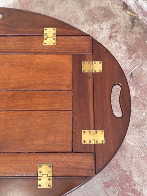 fig 5. An antique mahogany butlers tray with hinged folding sides and brass fittings resting on a rectangular wooden stand.