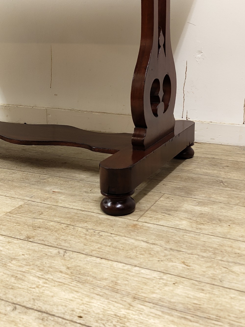 A Victorian mahogany washstand with a rectangular white marble top resting on twin pierced trestle supports linked by a shaped stretcher. View X