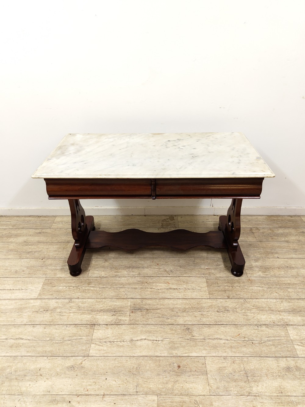 A Victorian mahogany washstand with a rectangular white marble top resting on twin pierced trestle supports linked by a shaped stretcher. View V