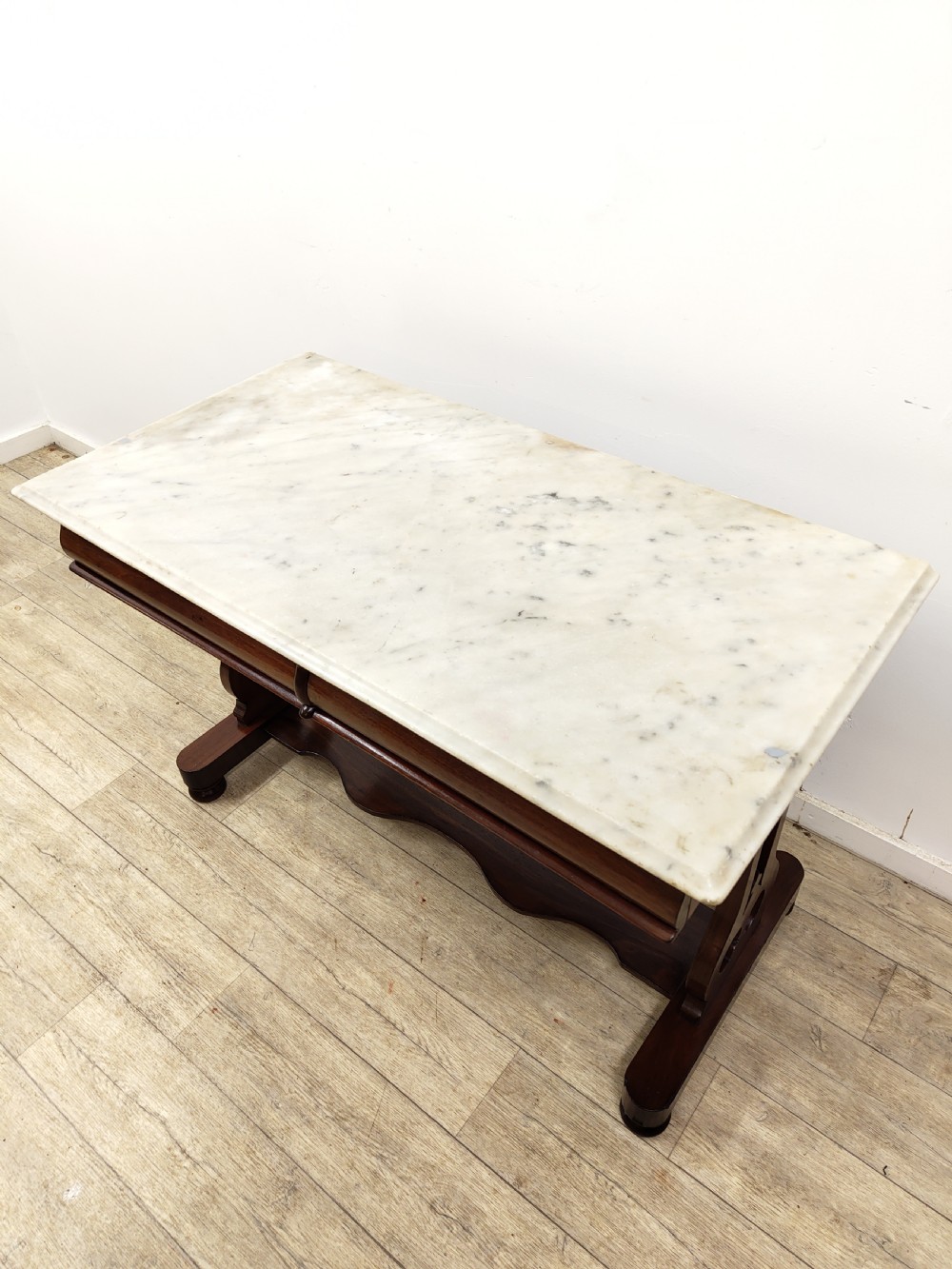 A Victorian mahogany washstand with a rectangular white marble top resting on twin pierced trestle supports linked by a shaped stretcher. View VI