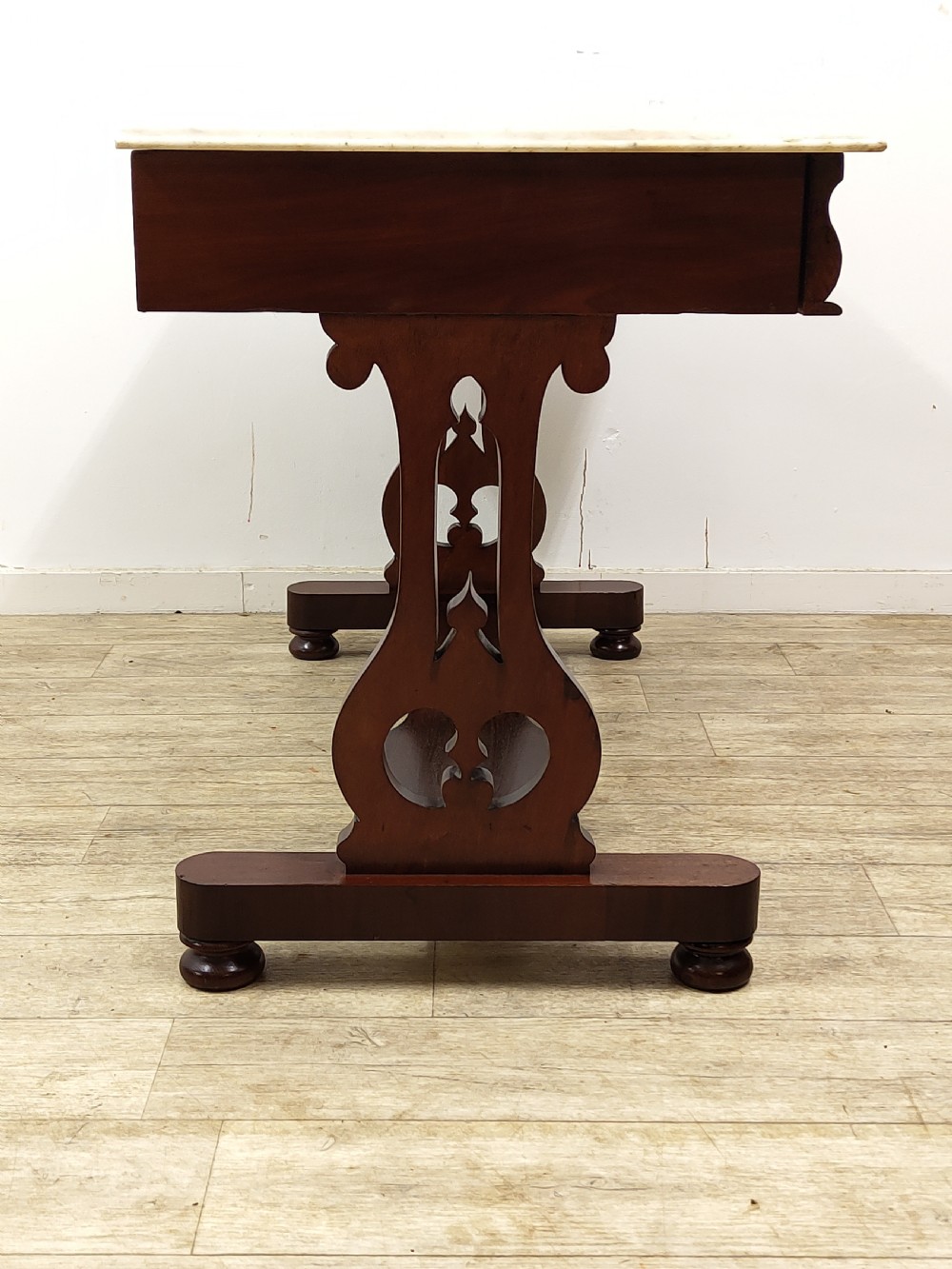 A Victorian mahogany washstand with a rectangular white marble top resting on twin pierced trestle supports linked by a shaped stretcher. View VIII