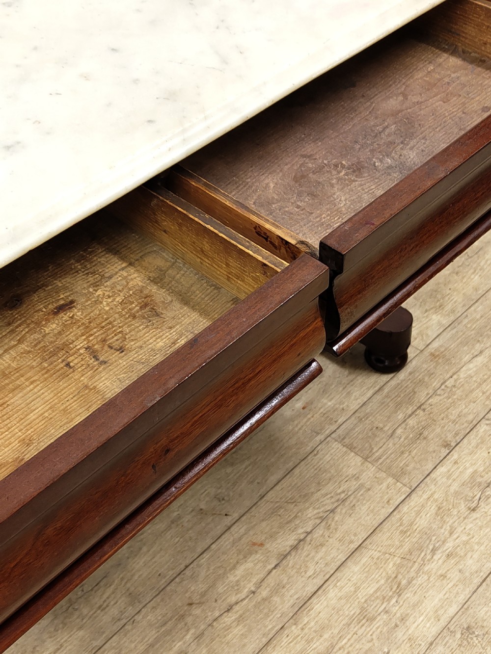 A Victorian mahogany washstand with a rectangular white marble top resting on twin pierced trestle supports linked by a shaped stretcher. View XI