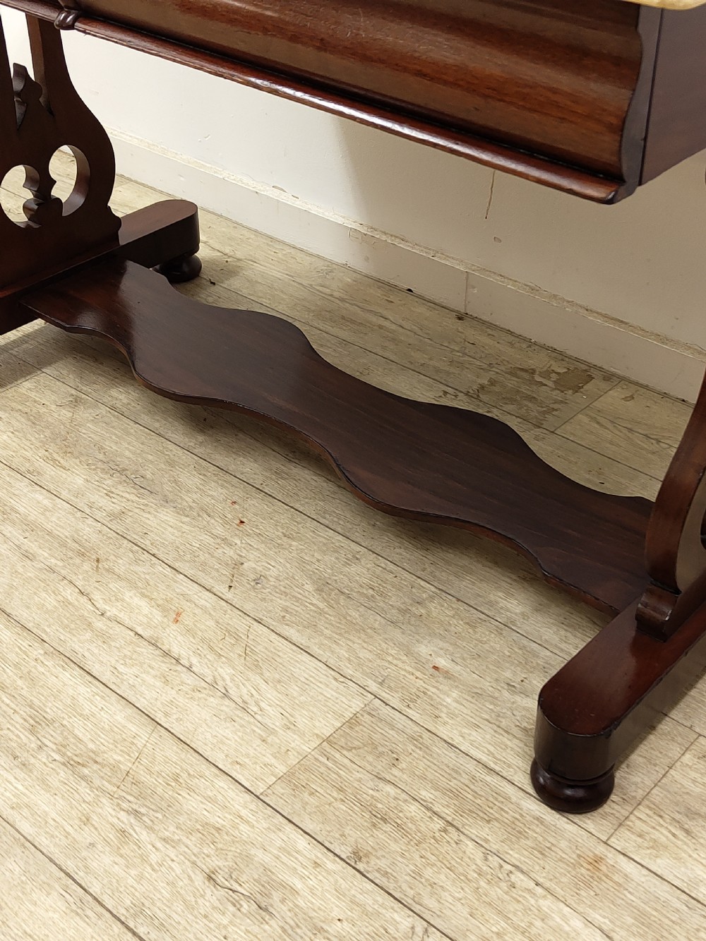 A Victorian mahogany washstand with a rectangular white marble top resting on twin pierced trestle supports linked by a shaped stretcher. View XIV