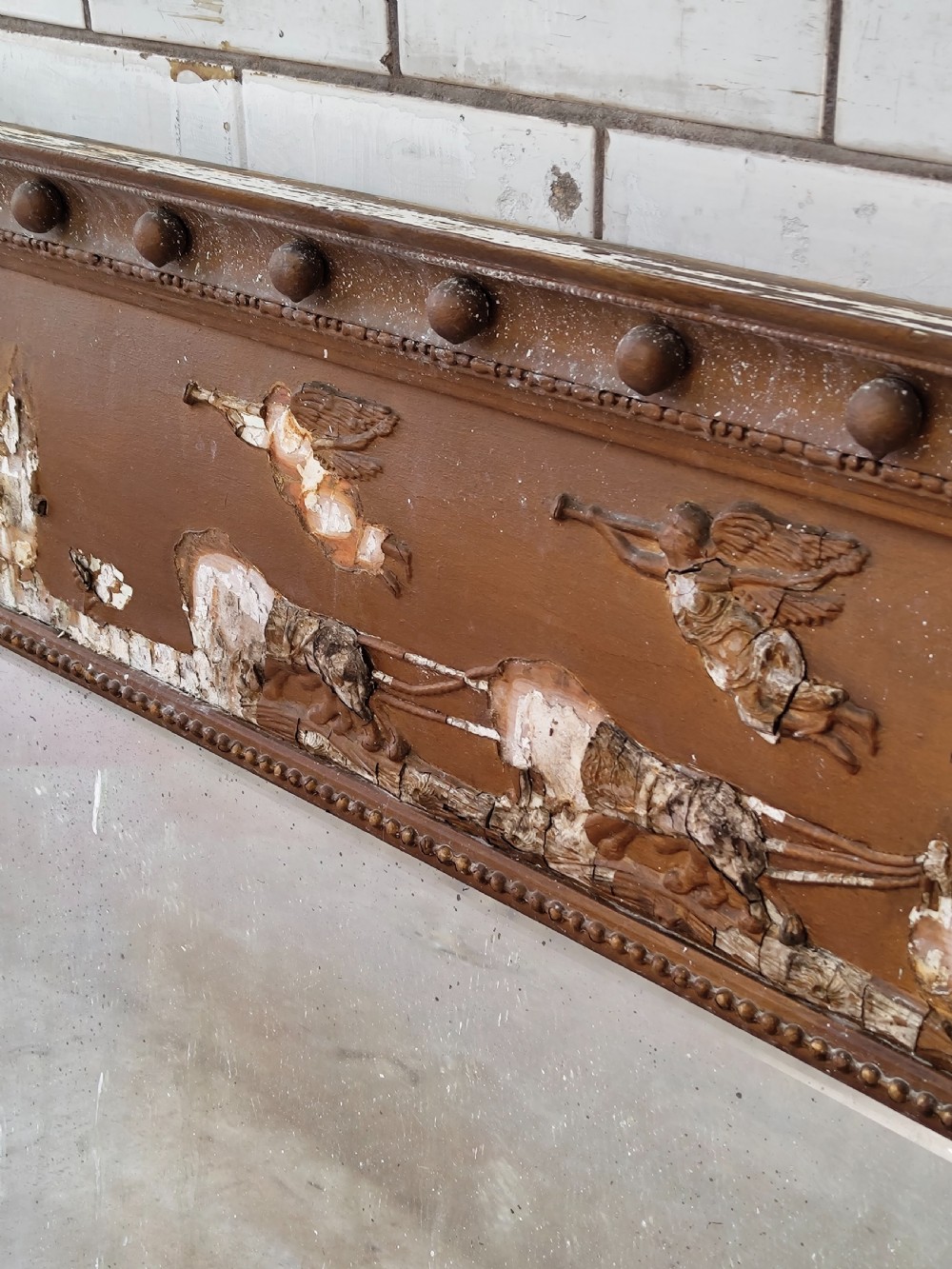 A pair of distressed Regency giltwood overmantel mirrors with classical relief friezes and tripartite mirror plates. View II