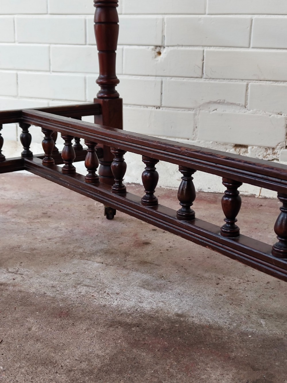 A solid walnut rectangular centre table featuring turned legs, a spindle-galleried lower stretcher, and brass castors. View V