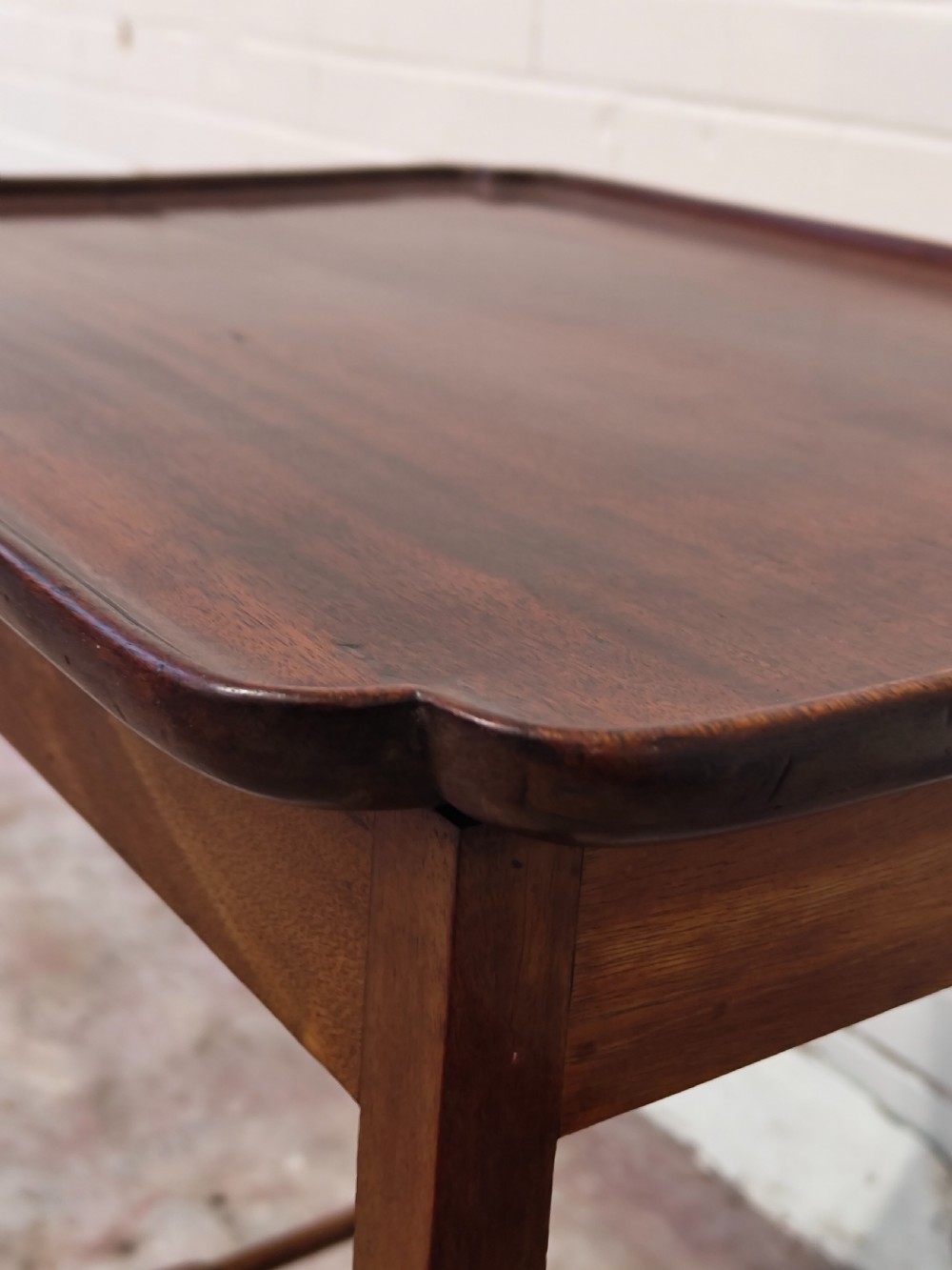 A tall Edwardian mahogany occasional table featuring a tray top with raised edges and slender spider legs connected by lower stretchers. View IV