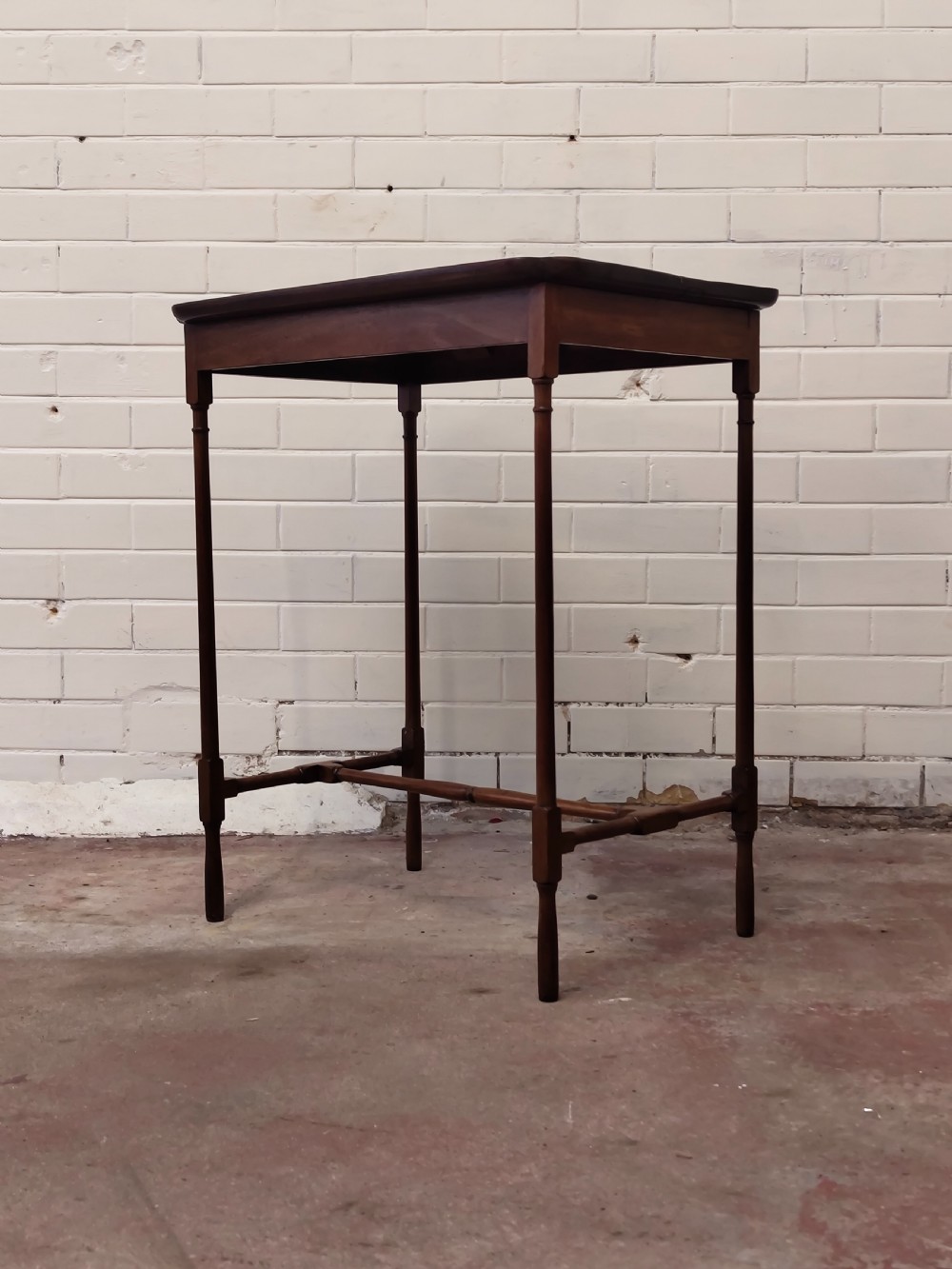 A tall Edwardian mahogany occasional table featuring a tray top with raised edges and slender spider legs connected by lower stretchers. View V
