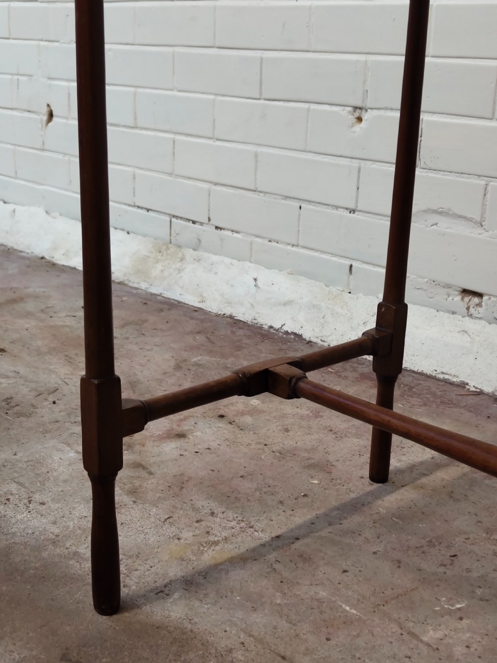 A tall Edwardian mahogany occasional table featuring a tray top with raised edges and slender spider legs connected by lower stretchers. View IX