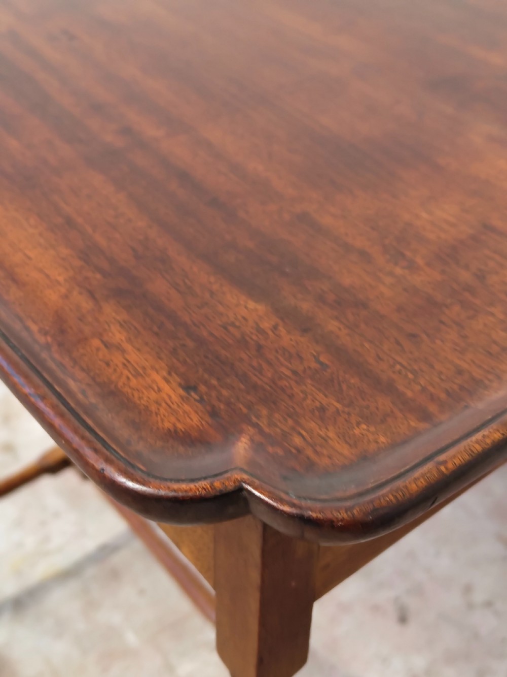 A tall Edwardian mahogany occasional table featuring a tray top with raised edges and slender spider legs connected by lower stretchers. View X