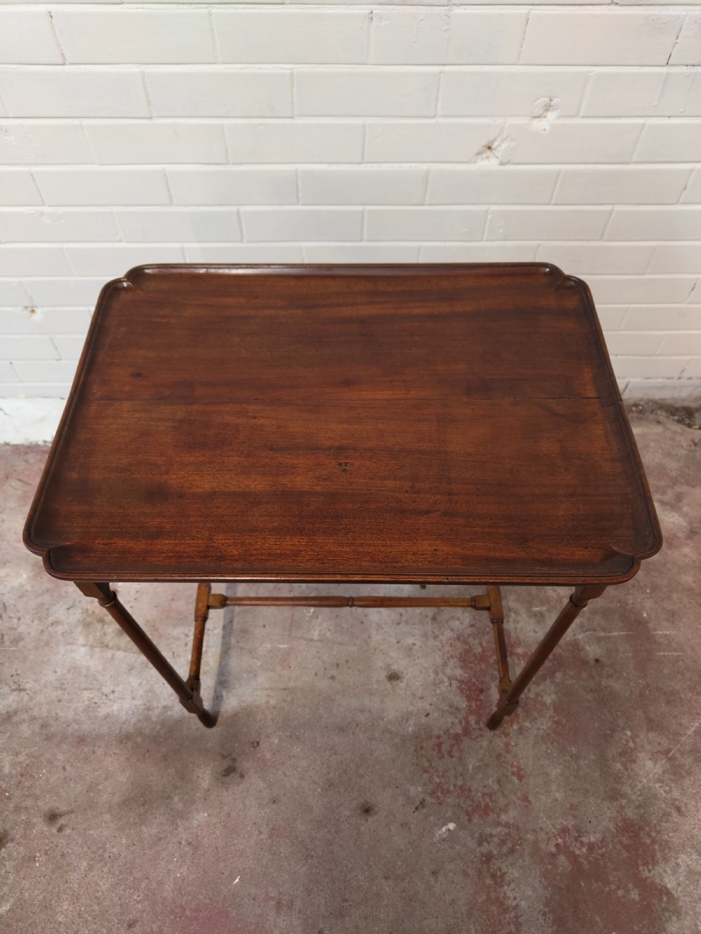 A tall Edwardian mahogany occasional table featuring a tray top with raised edges and slender spider legs connected by lower stretchers. View XI