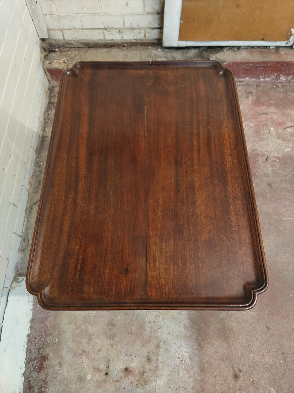 A tall Edwardian mahogany occasional table featuring a tray top with raised edges and slender spider legs connected by lower stretchers. View XII