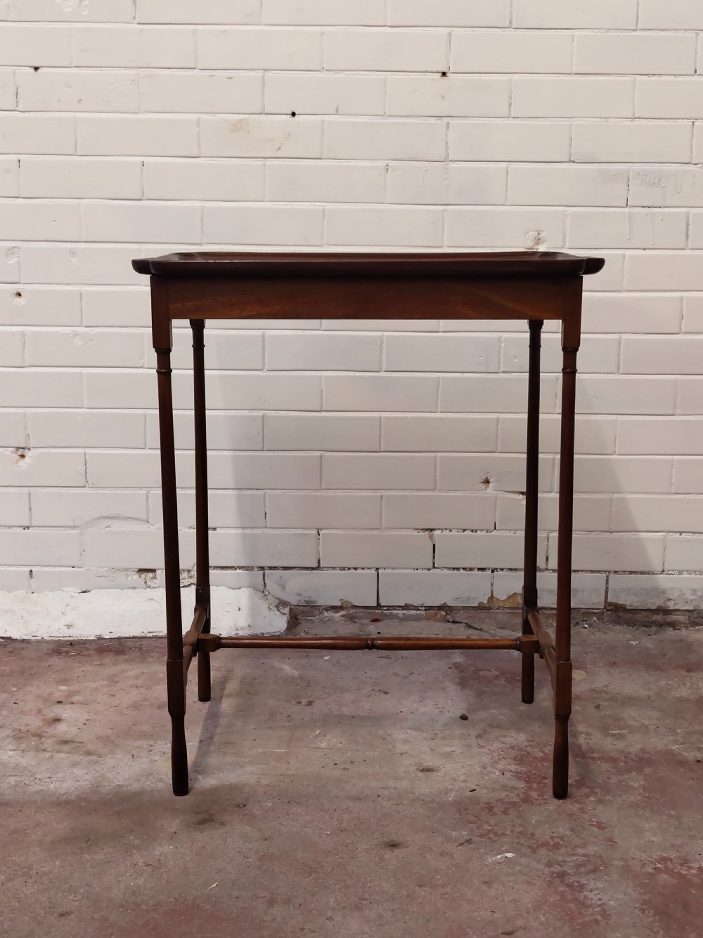 A tall Edwardian mahogany occasional table featuring a tray top with raised edges and slender spider legs connected by lower stretchers. View XIII