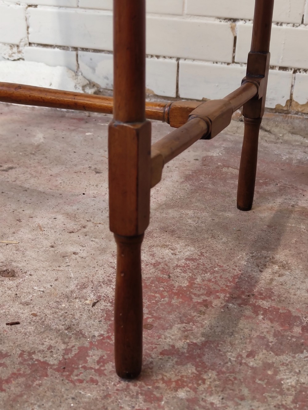 A tall Edwardian mahogany occasional table featuring a tray top with raised edges and slender spider legs connected by lower stretchers. View XIV