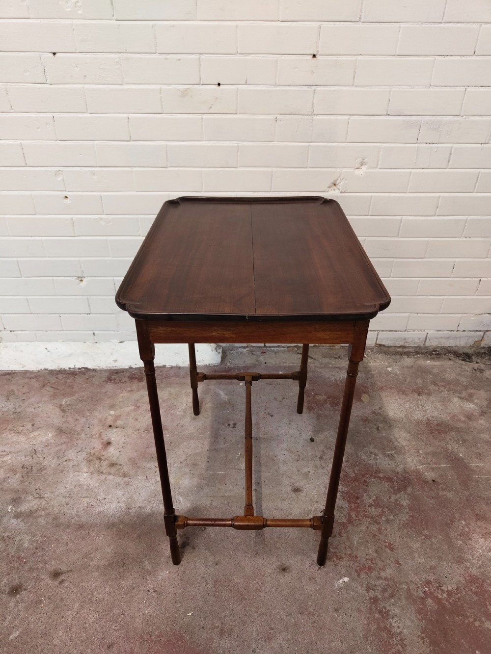 A tall Edwardian mahogany occasional table featuring a tray top with raised edges and slender spider legs connected by lower stretchers. View XVI