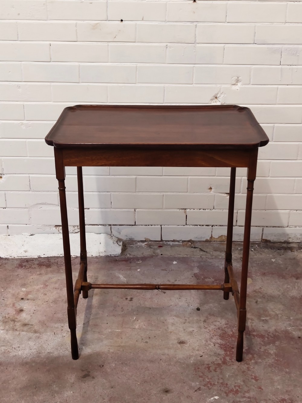 A tall Edwardian mahogany occasional table featuring a tray top with raised edges and slender spider legs connected by lower stretchers. View XVIII