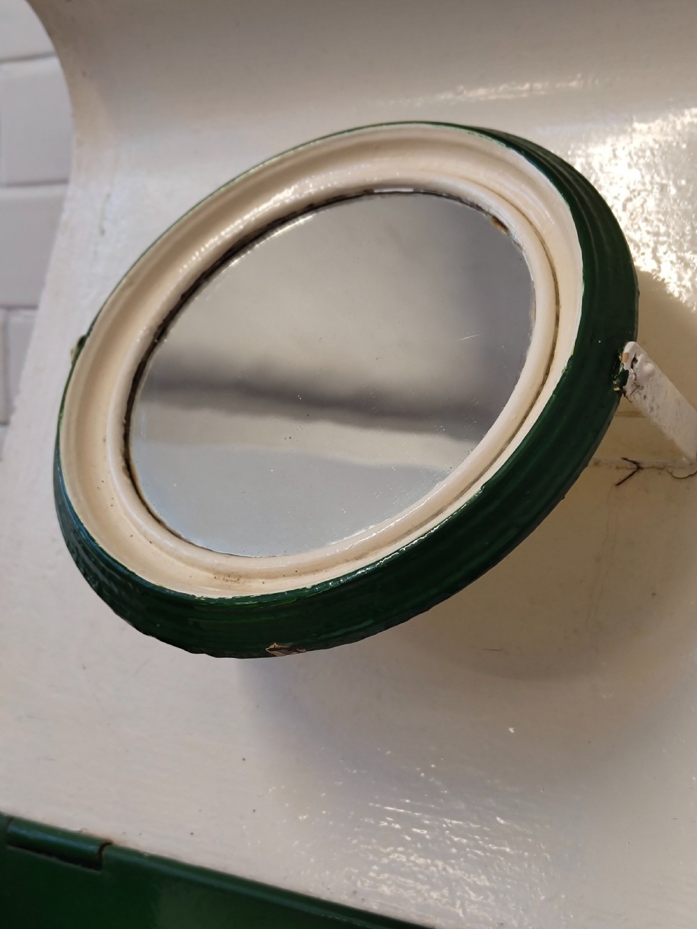 A hand-painted black and green metal toleware washstand with an open lid revealing a circular mirror and a fitted ceramic washbasin. View XXI