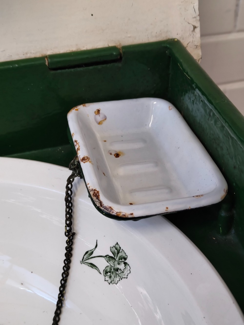 A hand-painted black and green metal toleware washstand with an open lid revealing a circular mirror and a fitted ceramic washbasin. View VI