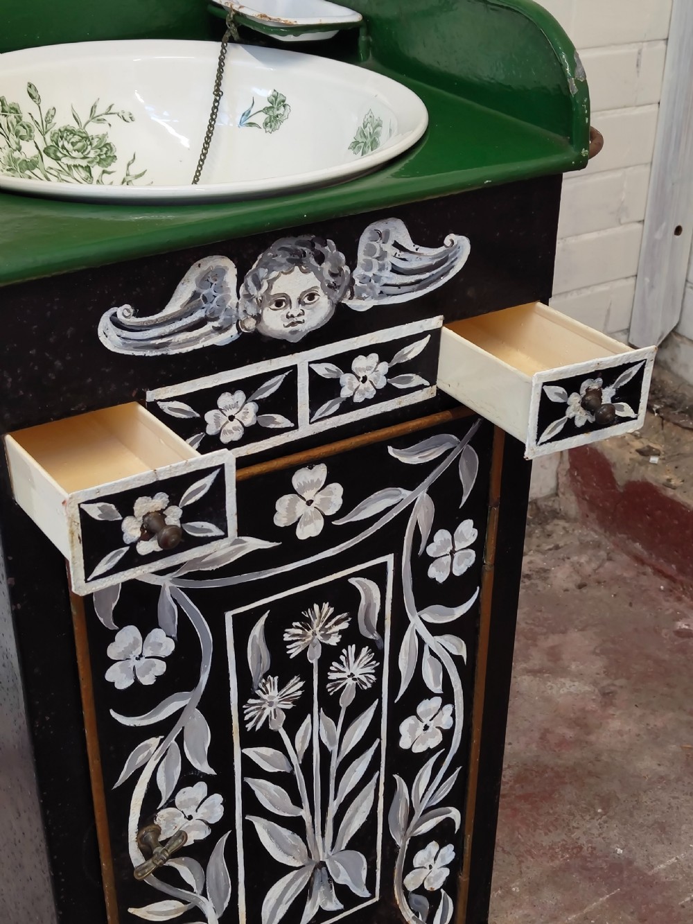 A hand-painted black and green metal toleware washstand with an open lid revealing a circular mirror and a fitted ceramic washbasin. View XII