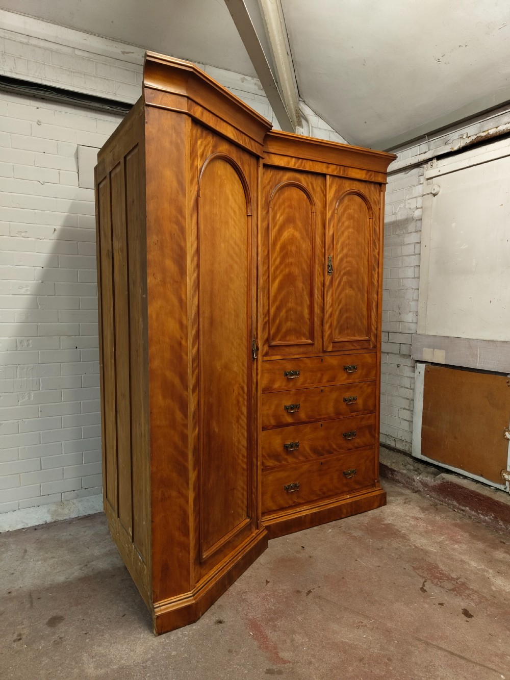 Victorian satin birch corner compactum wardrobe featuring arched panelled doors, brass hardware, and a integrated chest of drawers. View VIII