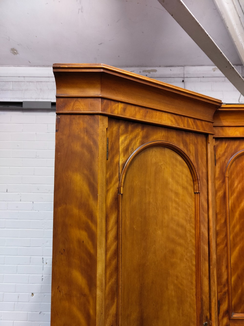 Victorian satin birch corner compactum wardrobe featuring arched panelled doors, brass hardware, and a integrated chest of drawers. View III