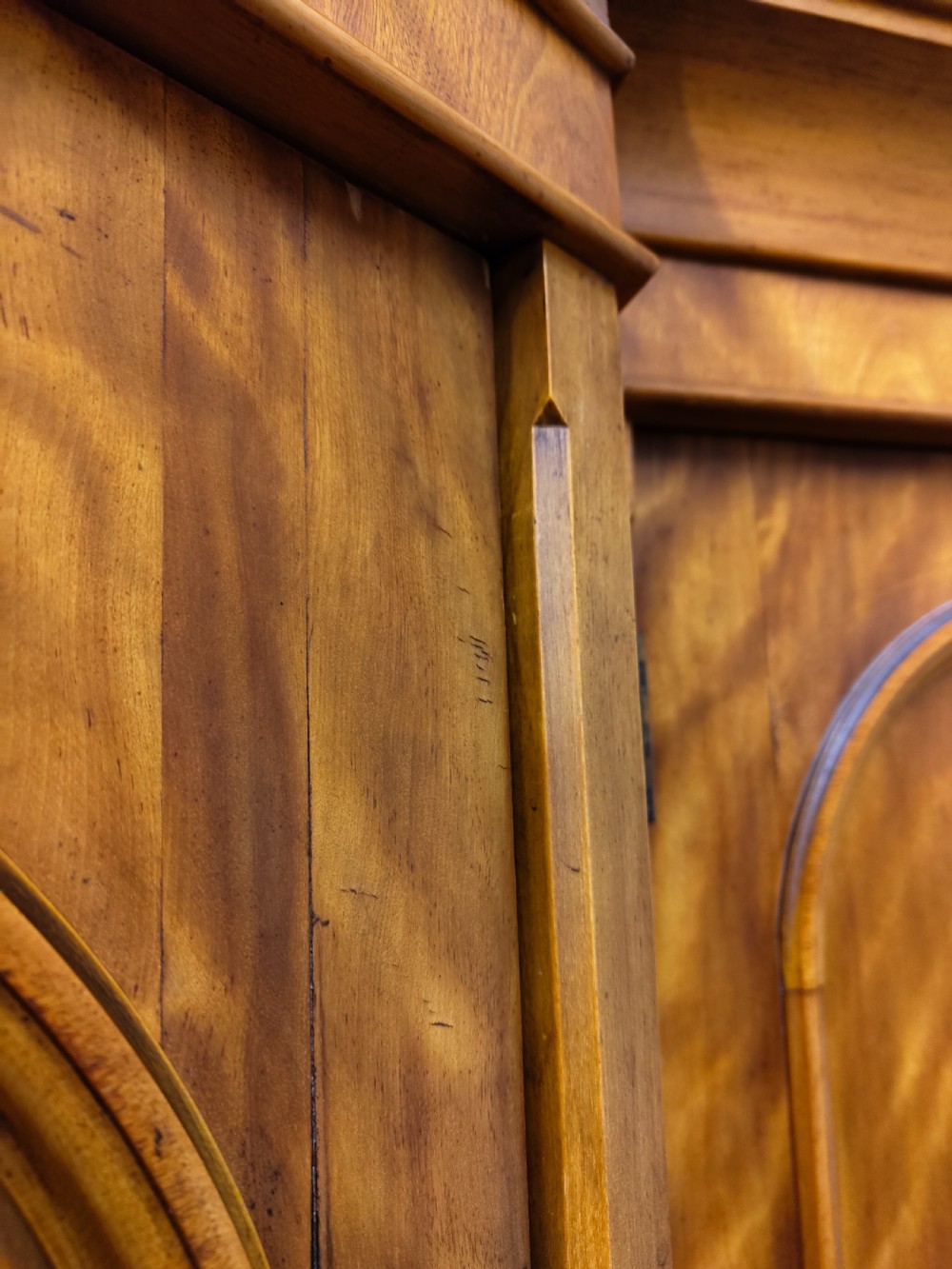 Victorian satin birch corner compactum wardrobe featuring arched panelled doors, brass hardware, and a integrated chest of drawers. View IV