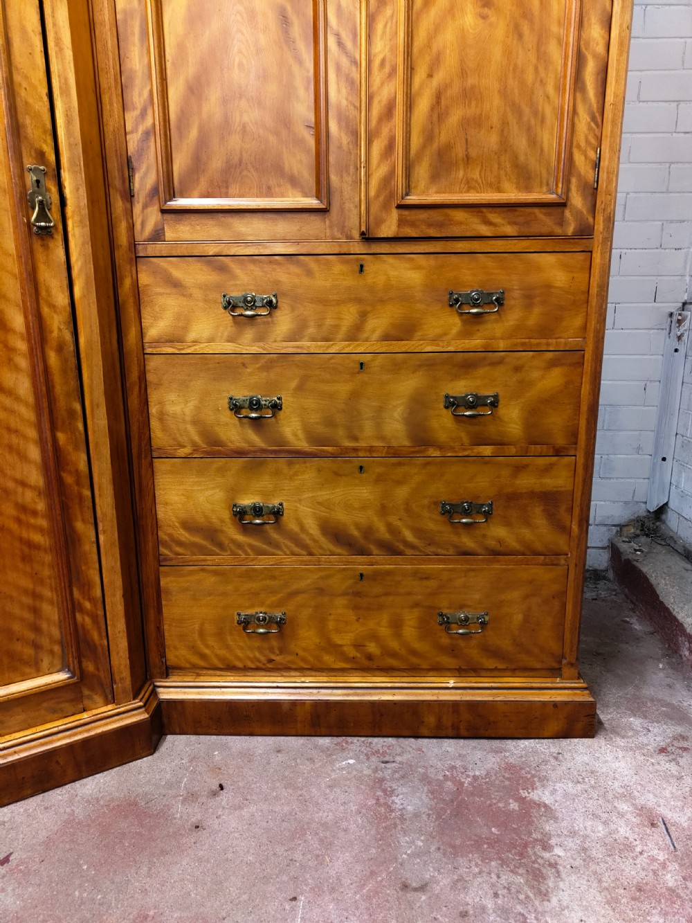Victorian satin birch corner compactum wardrobe featuring arched panelled doors, brass hardware, and a integrated chest of drawers. View IX