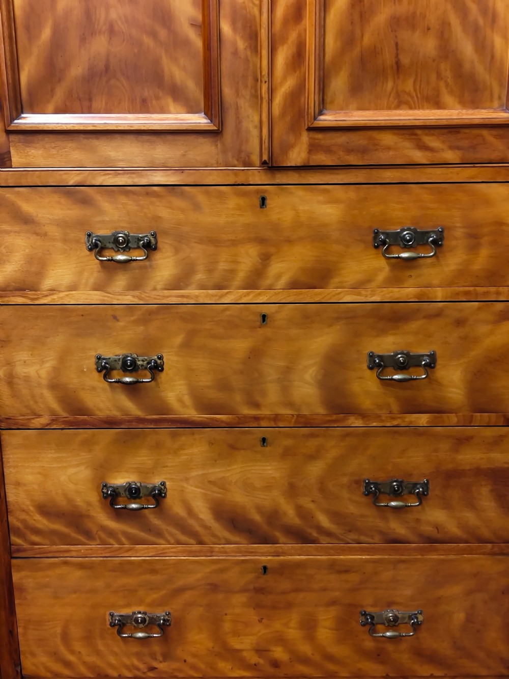Victorian satin birch corner compactum wardrobe featuring arched panelled doors, brass hardware, and a integrated chest of drawers. View X