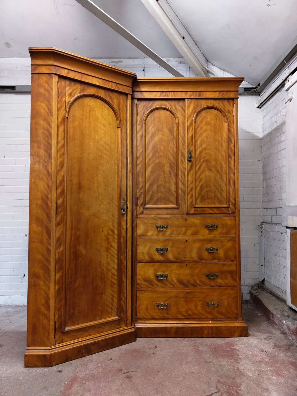 Victorian satin birch corner compactum wardrobe featuring arched panelled doors, brass hardware, and a integrated chest of drawers. View XII