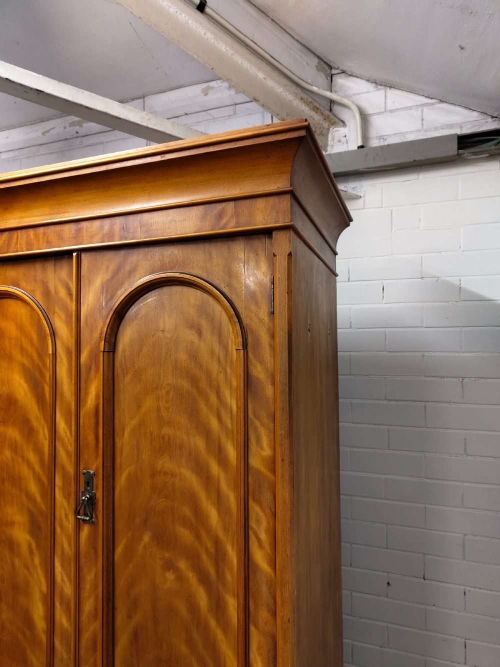 Victorian satin birch corner compactum wardrobe featuring arched panelled doors, brass hardware, and a integrated chest of drawers. View XVI