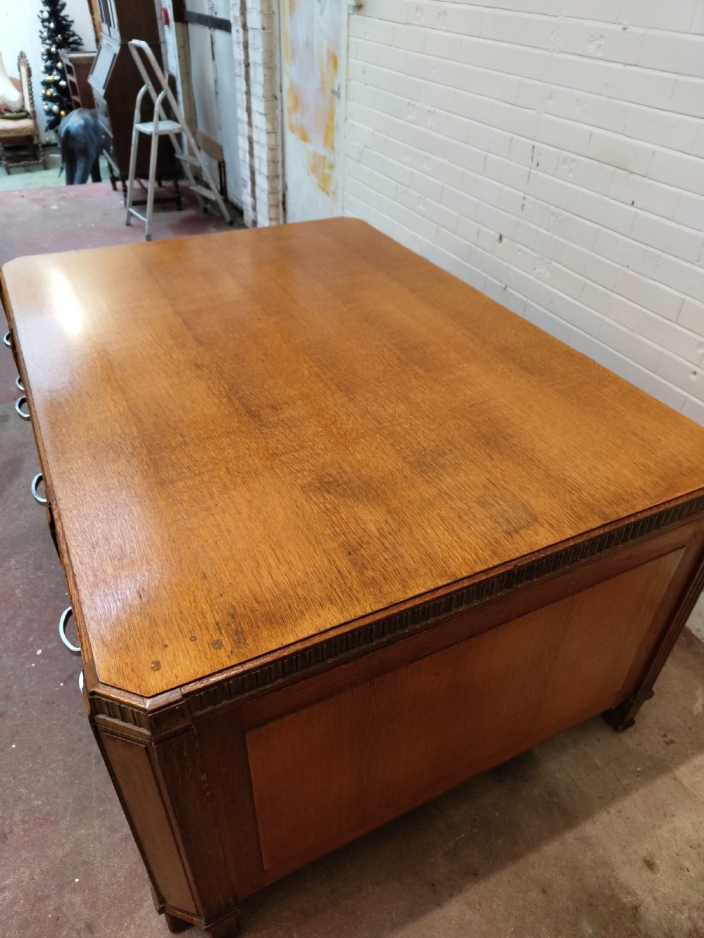 A large golden oak Art Deco partners desk featuring reeded corner details, dual pedestals with drawers, and metal pull handles. View III