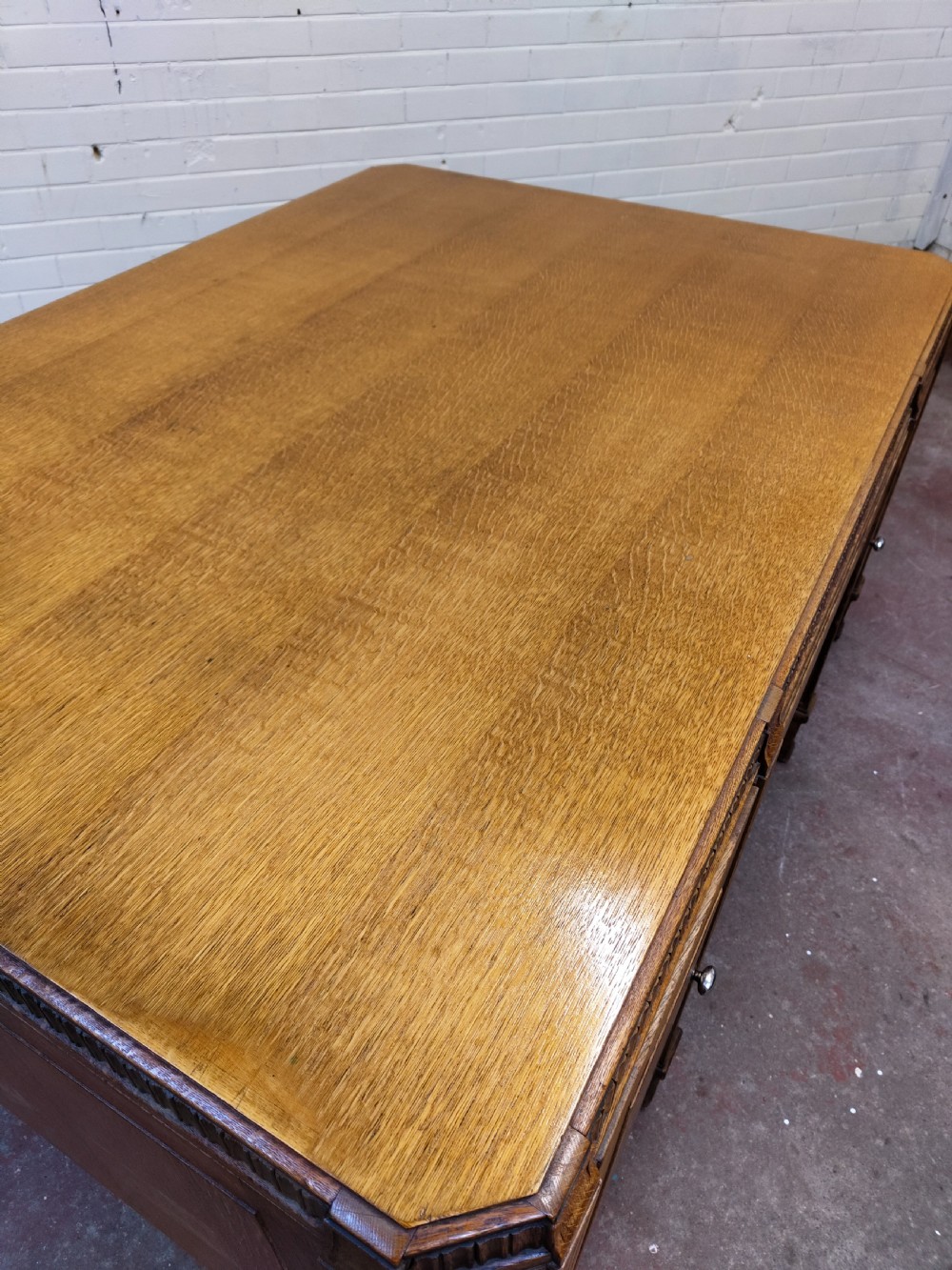 A large golden oak Art Deco partners desk featuring reeded corner details, dual pedestals with drawers, and metal pull handles. View XX