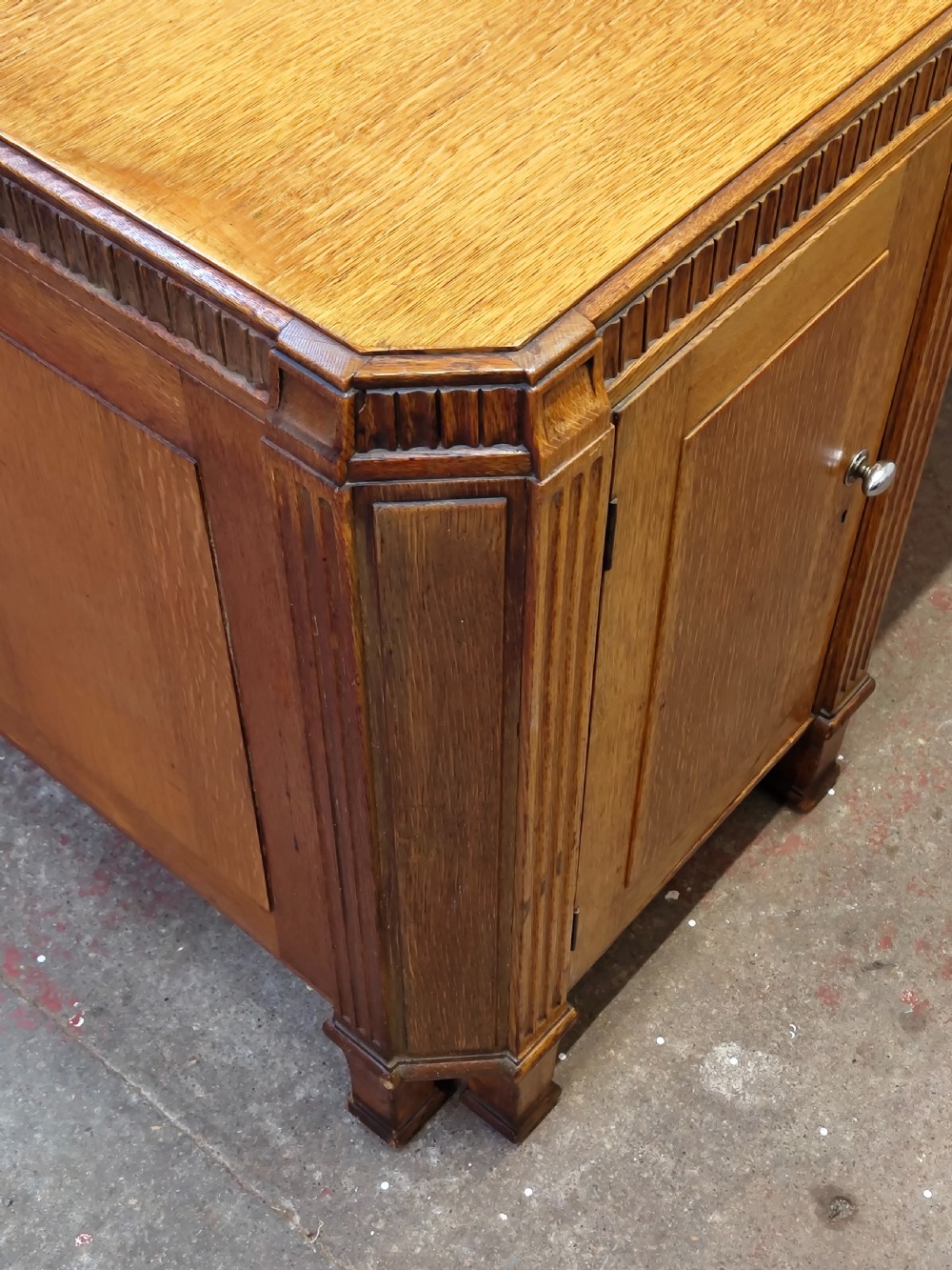 A large golden oak Art Deco partners desk featuring reeded corner details, dual pedestals with drawers, and metal pull handles. View XXIII