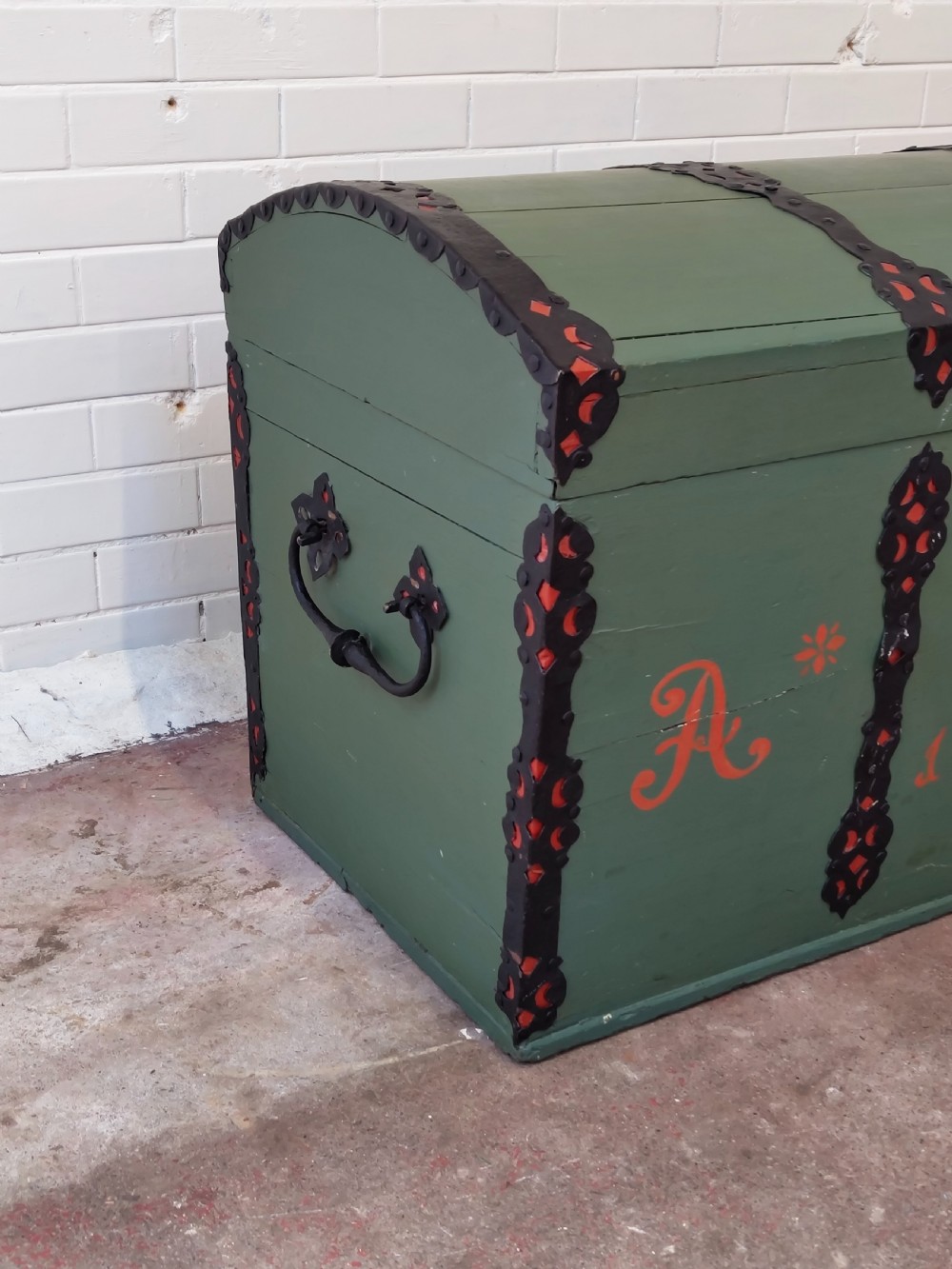 A green painted wooden dome top trunk featuring black decorative iron straps, red painted initials AH, and the date 1709. View III