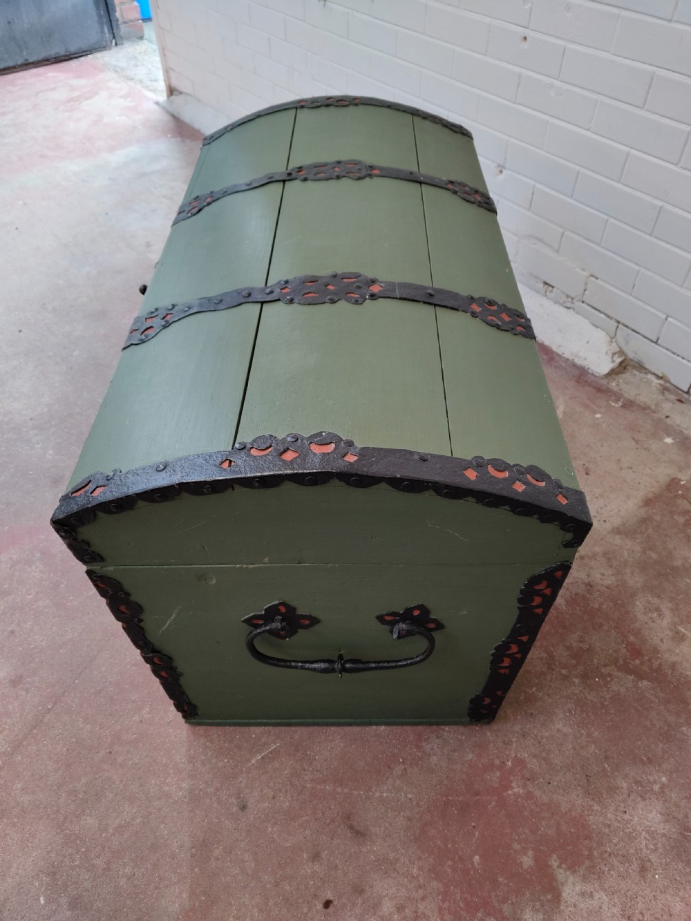 A green painted wooden dome top trunk featuring black decorative iron straps, red painted initials AH, and the date 1709. View XII