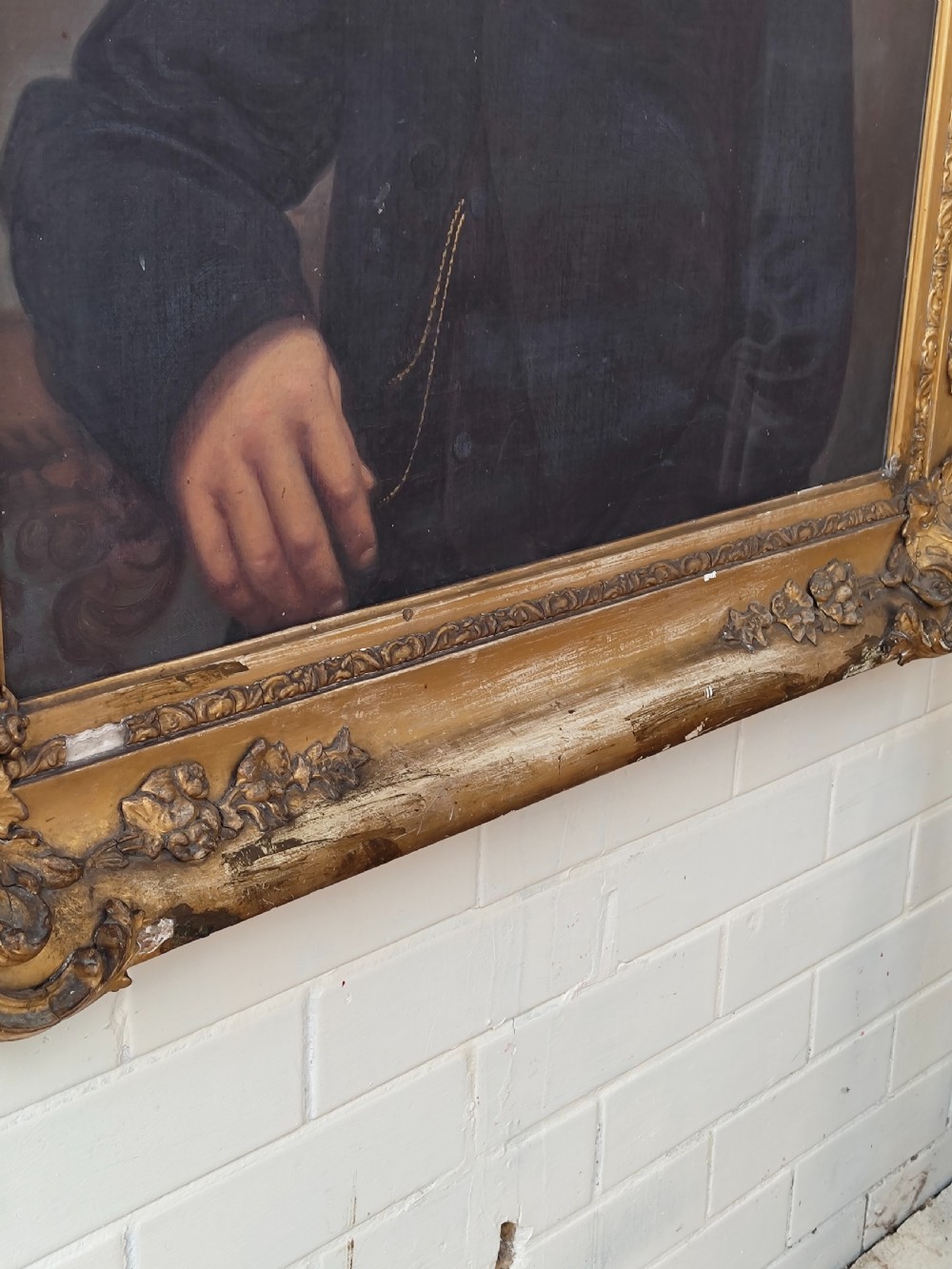 A Victorian oil painting depicting a seated gentleman in a dark suit set inside a large, ornate gilded gesso frame. View XI