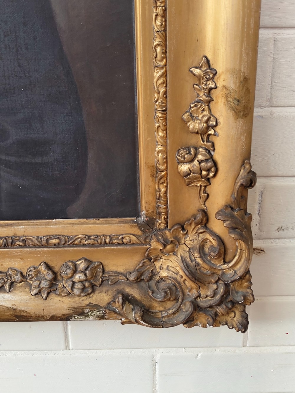 A Victorian oil painting depicting a seated gentleman in a dark suit set inside a large, ornate gilded gesso frame. View XVII