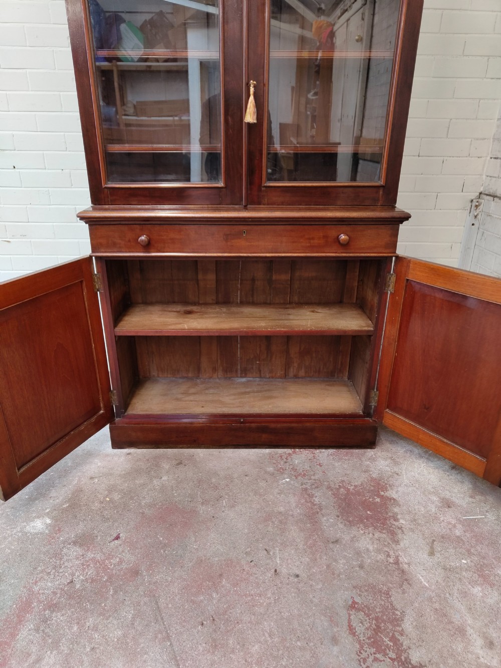 A tall Victorian mahogany bookcase featuring a glazed upper display cabinet with adjustable shelves over a lower two-door cupboard with flame mahogany veneer panels. View XIII