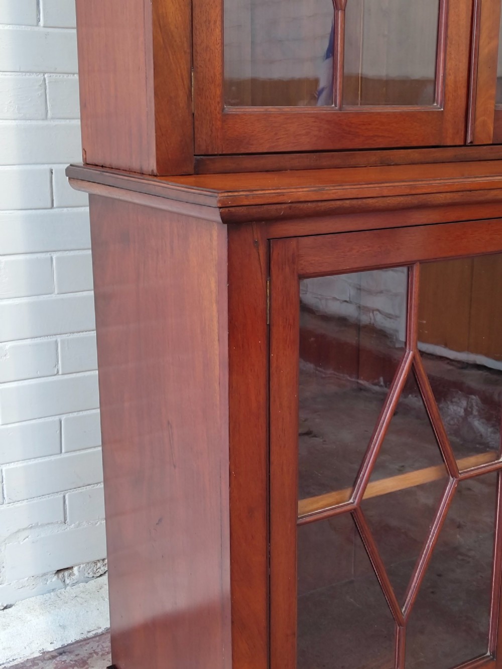 A tall Victorian mahogany bookcase featuring upper and lower double doors with diamond astragal glazed panels and adjustable interior shelves. View IV